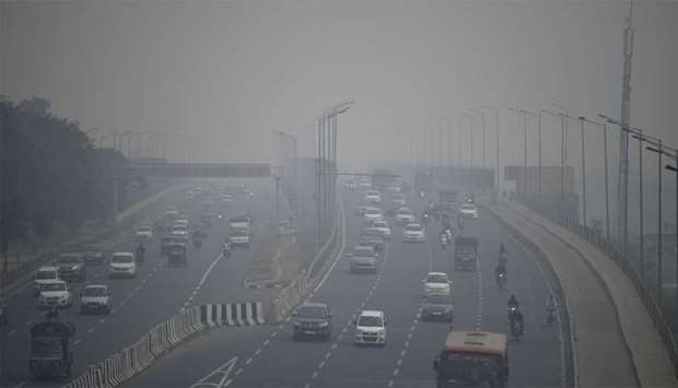 Commuters drive along a motorway under heavy smog conditions in New Delhi