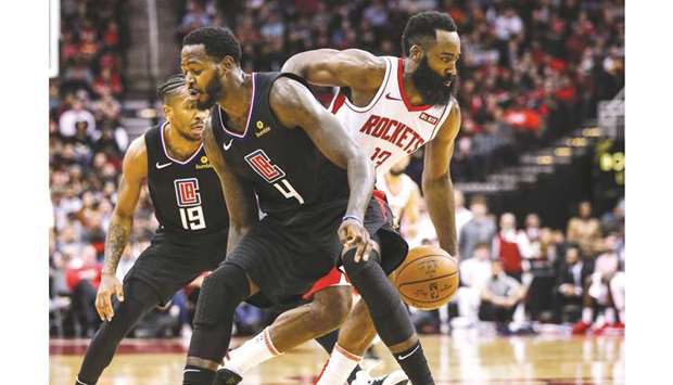 Houston Rockets guard James Harden (right) dribbles the ball around Los Angeles Clippers forward JaMychal Green (centre) during the third quarter of the NBA at Toyota Center in Houston, Texas, United States, on Wednesday. (USA TODAY Sports)