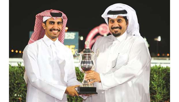 Al Jeryan Stud representative Mohamed bin Hamad al-Attiyah receives the owneru2019s trophy from QREC CEO Nasser Sherida al-Kaabi yesterday after Al Lusail won the Ras Laffan Cup. PICTURES: Juhaim
