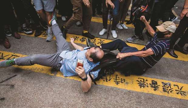 A man is beaten after getting in an argument during a demonstration of office workers and protesters, in Central in Hong Kong yesterday.
