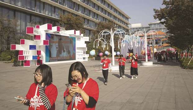 Employees walk through the campus at the Alibaba Group Holding headquarters during the annual Singlesu2019 Day online shopping event in Hangzhou, China, on November 11. The largest Chinese e-commerce company has capped the 12.5mn shares available to individual investors at HK$188 apiece, making it the most expensive first-time share sale in Hong Kong.