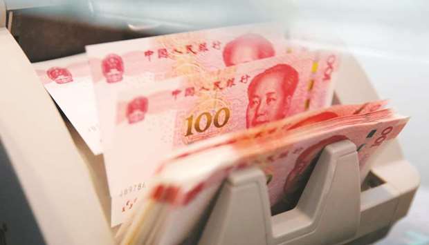 Chinese 100 yuan banknotes are seen in a counting machine at a branch of a commercial bank in Beijing (file). The Peopleu2019s Bank of China offered 200bn yuan ($29bn) of one-year loans to banks yesterday. It kept the interest rate unchanged at 3.25%, showing restraint in monetary policy after this weeku2019s worse-than-expected economic data.