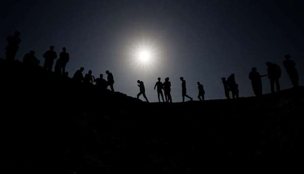 Palestinians gather at the scene of an Israeli air strike in the central Gaza Strip on Thursday