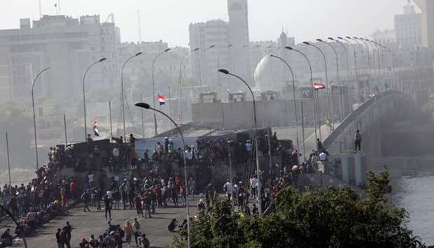Iraqi demonstrators are seen at Sinak Bridge during the ongoing anti-government protests, in Baghdad