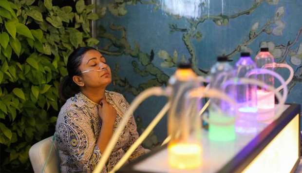 A Delhi resident breathes in oxygen mixed with aromatherapy via a nasal cannula, at an oxygen bar in New Delhi