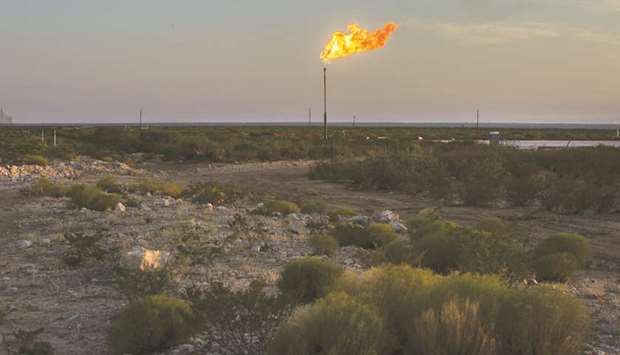A gas flare burns at dusk in the Permian Basin in Texas. American oil production has more than doubled in the past decade but itu2019s come at a cost u2013 almost $200bn of negative cash flow.