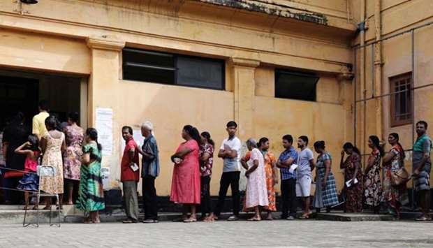 People stand in a line to cast their votes during the presidential election at polling station in Colombo, Sri Lanka