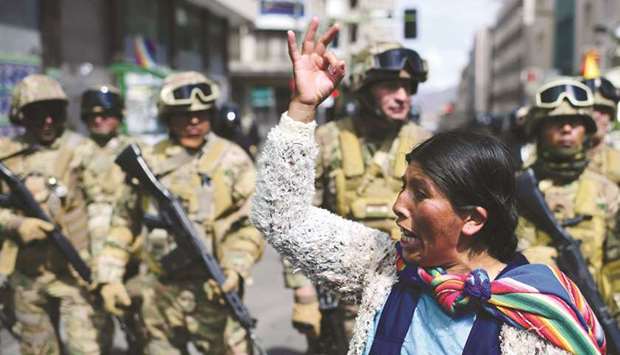 A Bolivian indigenous woman, a supporter of Bolivian ex-president Evo Morales, gestures in front of soldiers during a protest against the interim government in La Paz on Friday.