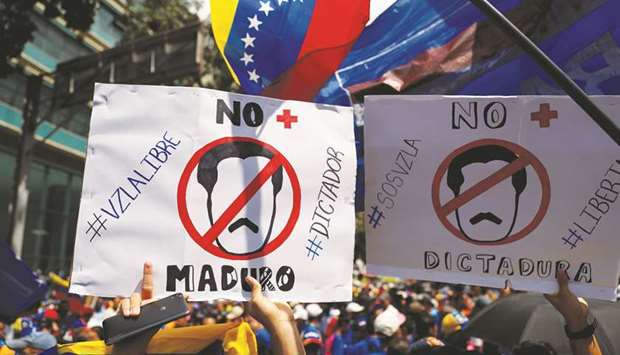 People hold placards saying u201cNo more Madurou201d during a protest march against Venezuelau2019s President Nicolas Maduro in Caracas yesterday.