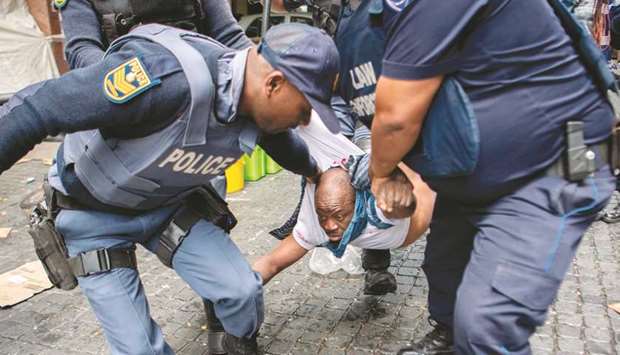 An October 30, 2019, file photo of South African police officers forcibly removing refugees camping outside the Cape Town offices of the United Nations Council for refugees.