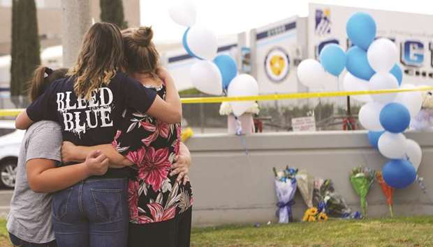 Mourners visit a makeshift memorial in front of the school for victims of the shooting in Santa Clarita, California.