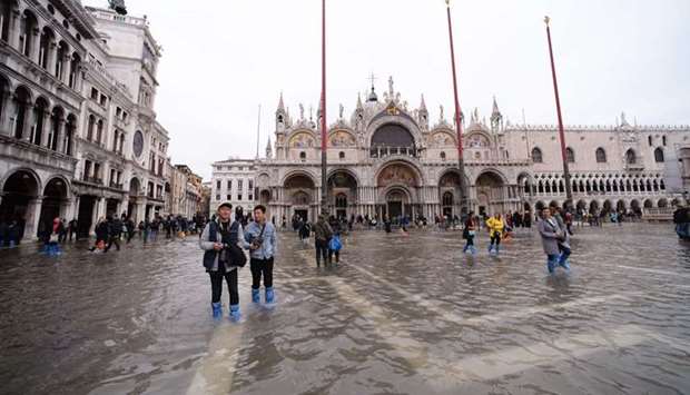 Tourists walks in St. Mark square yesterday in Venice, three days after the city suffered the highest tide in 50 years