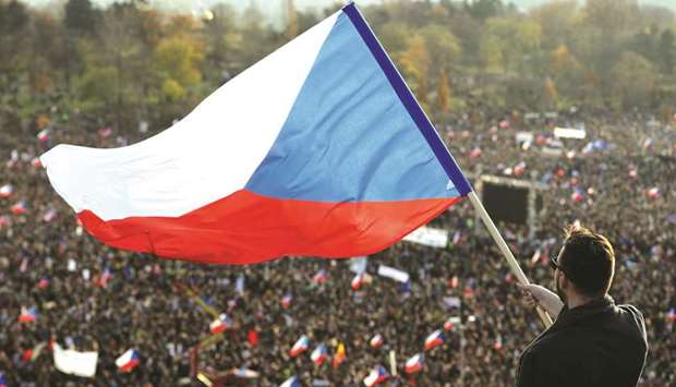 A man waves the Czech flag as demonstrators attend an anti-government rally in Prague yesterday, a day ahead of the 30th anniversary of the 1989 Velvet Revolution that led to the fall of Communism in former Czechoslovakia.