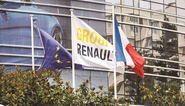 A Group Renault flag flies between a European Union (EU) flag and a Franceu2019s national flag outside the Renault headquarters in the Boulogne Billancourt district of Paris. Renault holds 43% of Nissan, which has a 15% stake in Renault and a 34% controlling stake in Mitsubishi.