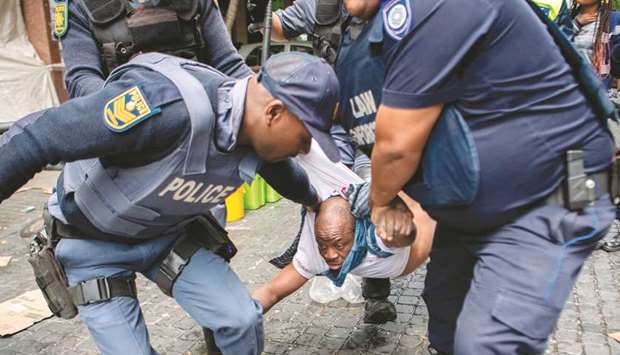 An October 30, 2019, file photo of South African police officers forcibly removing refugees camping outside the Cape Town offices of the United Nations Council for refugees.