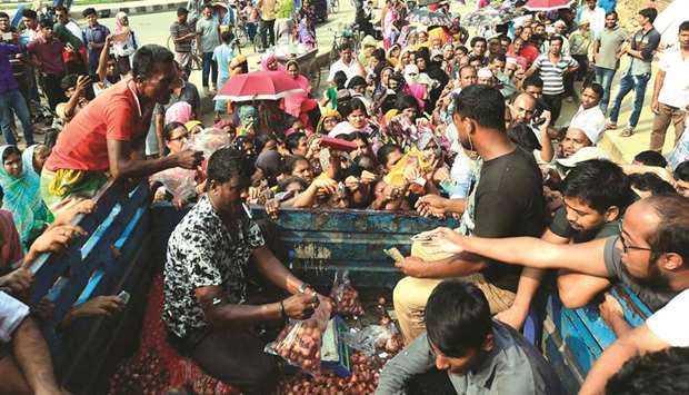 People scuffle as they purchase subsidised onions in Dhaka yesterday.