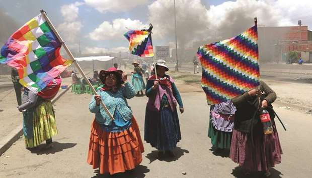 Supporters of the former president of Bolivia, Evo Morales, hold Wiphala flags during a protest in El Alto, near La Paz, Bolivia, yesterday.
