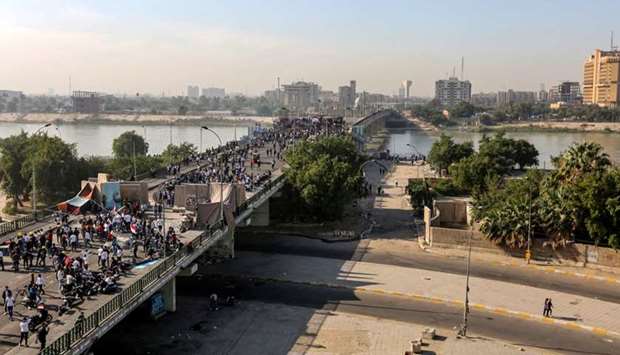 Iraqi anti-government protesters gather at a sit-in near barricades over al-Sinek bridge connecting the Iraqi capital Baghdad's Sinek district to the Salhiyeh district neighbouring the high-security Green Zone, which hosts government offices and foreign embassies, on November 17, 2019