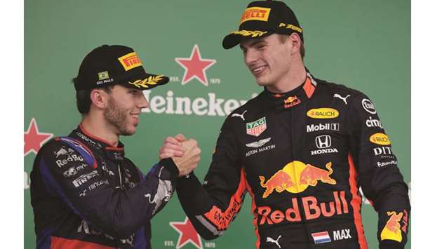 Race winner Red Bullu2019s Max Verstappen (right) shakes hands with second-placed Toro Rossou2019s Pierre Gasly on the podium for the Brazilian Grand Prix at the Interlagos track in Sao Paulo, Brazil, yesterday. (Reuters)