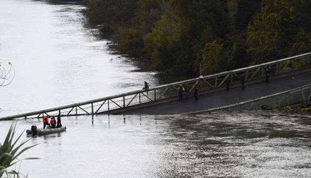 Rescuers sail near the suspension bridge which collapsed in Mirepoix-sur-Tarn, near Toulouse