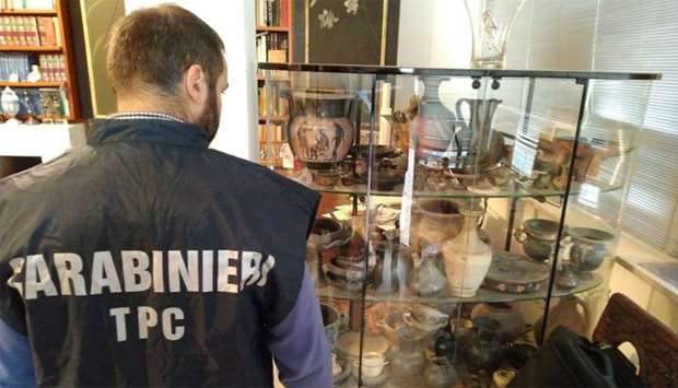 Carabinieri military policeman looks at artefacts in a display case in Cosenza, Italy