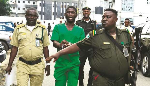 Suspected serial killer Gracious David West (C) being led to the courtroom by security men at the High Court in Port Harcout, Rivers State.