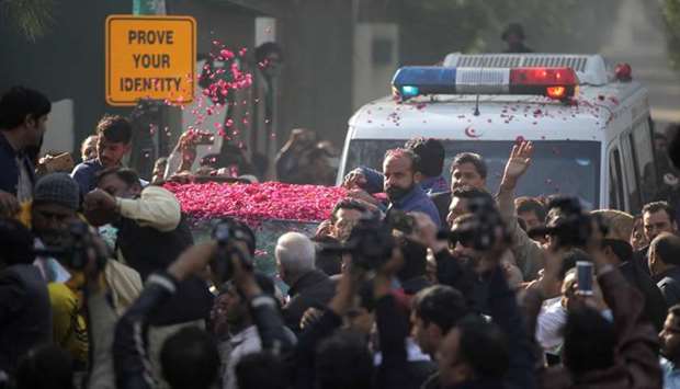 Supporters of Pakistan Muslim League-Nawaz (PML-N) sprinkle rose petals on a car carrying Former Prime Minister Nawaz Sharif, as he makes his way to the airport to travel for a medical treatment in the United Kingdom, outside his residence in Raiwind, near Lahore