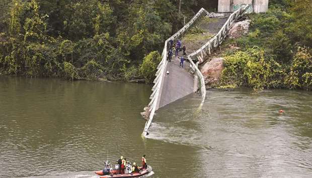 Rescuers sail near the collapsed suspension bridge in Mirepoix-sur-Tarn, near Toulouse, southwest France.