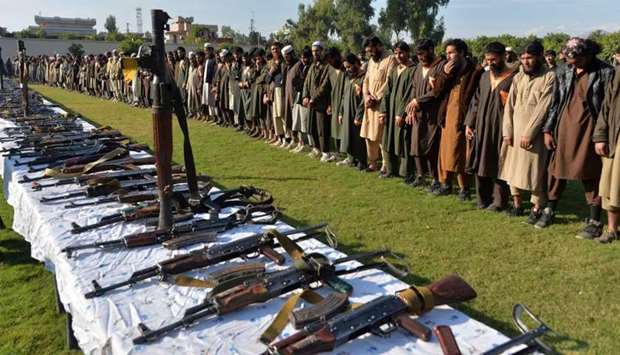 Members of the Islamic State (IS) group stand alongside their weapons, following they surrender to Afghanistan's government in Jalalabad, capital of Nangarhar Province.