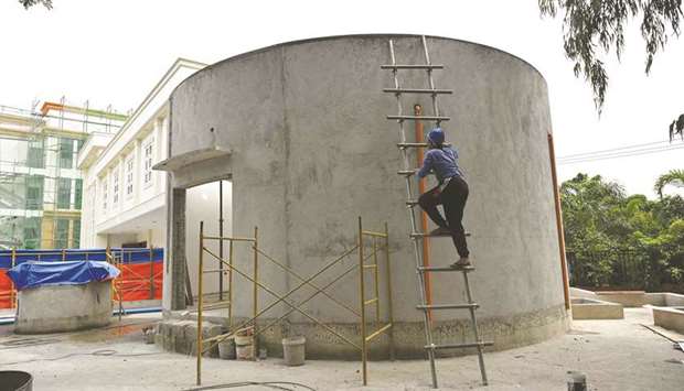 A worker climbs on the concrete entrance of the El Deposito, a Spanish-era water reservoir being rehabilitated for tourism, in San Juan town, suburban Manila.
