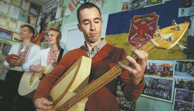 Senchukov plays a musical instrument made of safety matches during a rehearsal in the town of Zhashkiv, Ukraine.