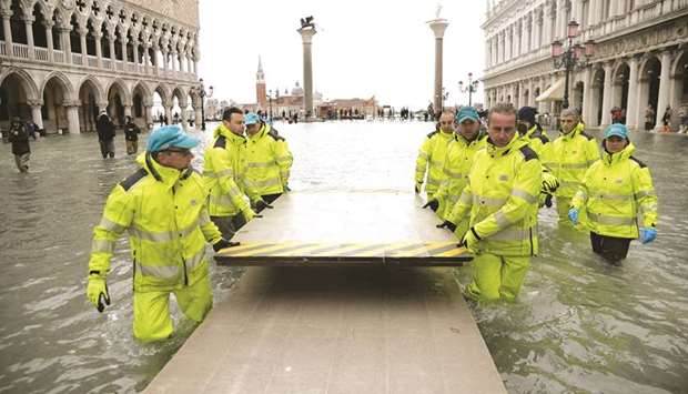 Workers install a mobile bridge in the flooded St Mark Square in Venice, prior to an u2018acqua altau2019 (high water), of 160cm (over 5u2019).