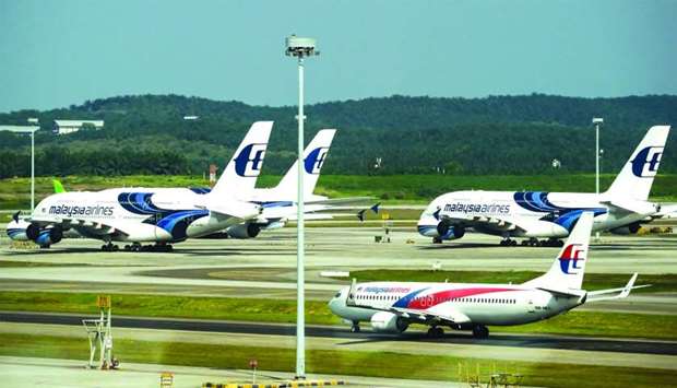 A Boeing Co 737-800 aircraft, operated by Malaysian Airlines, stands in front of Airbus SE A380 aircraft, on the tarmac at Kuala Lumpur International Airport in Malaysia. Both the leading aircraft manufacturers u2014 Boeing and Airbus have recently presented a promising outlook for the Middle Eastu2019s aviation industry.