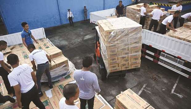 Coast guard personnel load food packs onto a truck destined for victims of recent earthquakes on Mindanao island in the southern Philippines, at a welfare warehouse in Manila, yesterday.