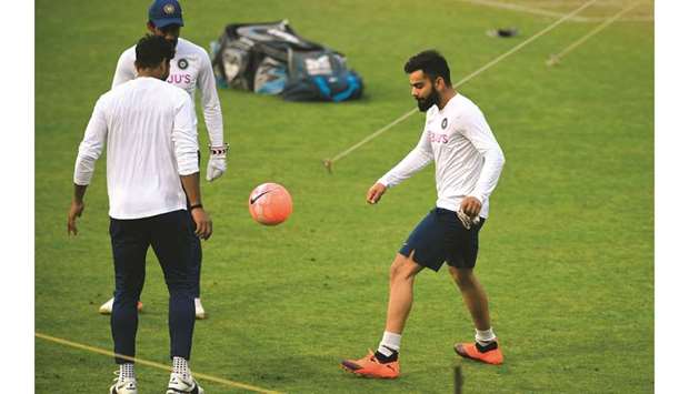 Virat Kohli (right) kicks a soccer ball during a practice session at The Eden Gardens cricket stadium in Kolkata yesterday. (AFP)