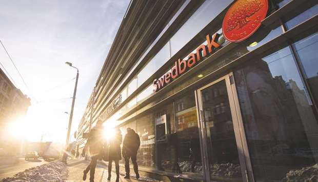 Pedestrians pass a Swedbank bank branch in Riga. Swedenu2019s oldest bank and biggest mortgage lender is being investigated in Estonia, Latvia, Sweden and the US amid allegations that it may have handled more than $100bn in potentially suspicious transactions via its Baltic operations.