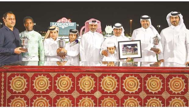 REC deputy chief steward Abdulla Rashid al-Kubaisi (third from right) with the winners of the Al Khor Cup after Topsy Turvy won the 1900m race at the Al Rayyan Park yesterday. PICTURES: Juhaim