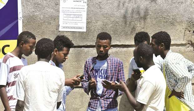 Men check vote results at one of the polling stations a day after the Sidama referendum on  semi-autonomy took place, in Hawassa yesterday.