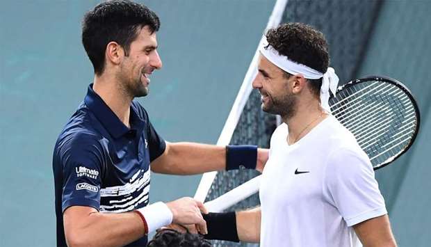 Serbia's Novak Djokovic (L) is congratulated by Bulgaria's Grigor Dimitrov after winning their men's singles semi-final tennis match at the ATP World Tour Masters