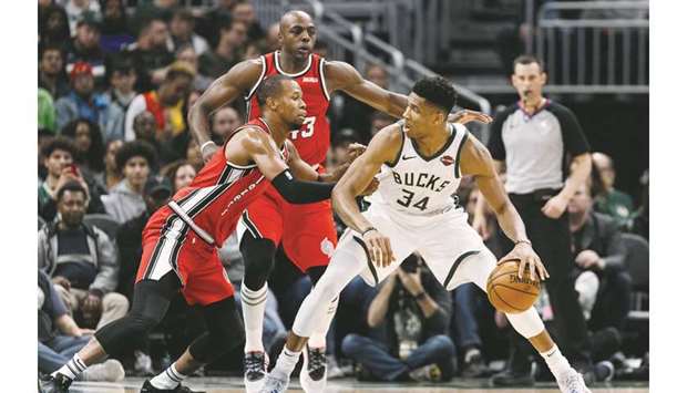 Milwaukee Bucks forward Giannis Antetokounmpo dribbles the ball under pressure from Portland Trail Blazers guard Rodney Hood (left) and forward Anthony Tolliver during the second quarter at Fiserv Forum. PICTURE: USA TODAY Sports