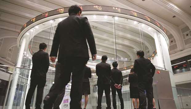 Visitors watch share prices at the Tokyo Stock Exchange. The Nikkei 225 closed up 0.3% to 23,122.88 points yesterday.