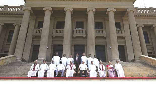 Sri Lankau2019s new President Gotabaya Rajapaksa (bottom fifth right) and his Prime Minister brother Mahinda Rajapaksa (bottom fifth left), along with cabinet ministers pose for a group photograph after the ministerial swearing-in ceremony in Colombo yesterday.