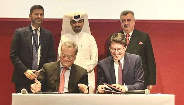 Italyu2019s Giorgio Marrapodi and Unescou2019s Paolo Fontani sign the agreement in Doha as ambassador Salzano and other dignitaries look on.