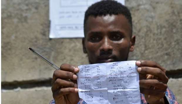 Tigistu Tesfaye, a Hawassa city resident and election observer, checking vote results at one of the polling stations one day after the Sidama referendum on semi-autonomy took place at in Hawassa on Thursday. AFP