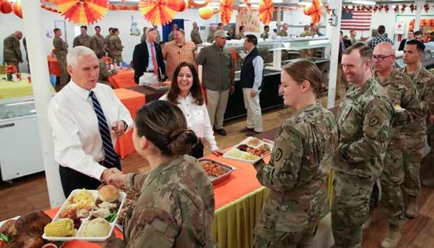 US Vice President Mike Pence and his wife Karen Pence help serve a Thanksgiving meal to US troops in a dining facility at Camp Flores on Al Asad Air Base, Iraq. Reuters