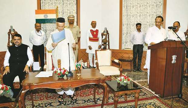 Mahrashtra Governor Bhagat Singh Koshyari administering oath of office to Nationalist Congress Party (NCP) leader Ajit Pawar (right) as deputy chief minister as Chief Minister Devendra Fadnavis looks on in Mumbai yesterday.