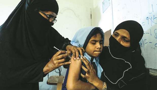 A student grimaces as she receives a free anti-typhoid vaccine during the immunisation campaign at a school in Karachi.