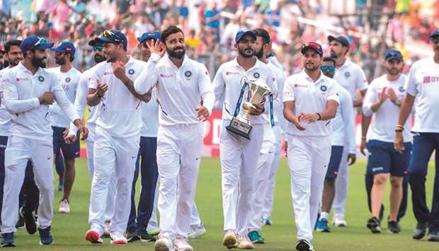 Indiau2019s captain Virat Kohli (third left) celebrates with teammates after winning the match during the third day of the second Test against Bangladesh at the Eden Gardens in Kolkata yesterday. (AFP)