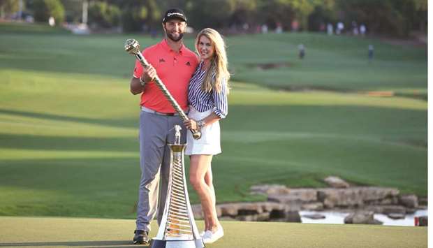 Jon Rahm of Spain celebrates with his fiancee, Kelley Cahill, after winning the DP World Tour Championship in Dubai yesterday. (AFP)