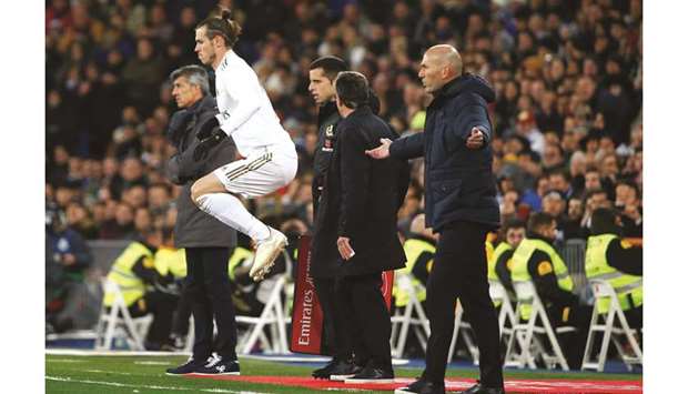 Real Madrid coach Zinedine Zidane (right) reacts as Gareth Bale gets ready to come on as a substitute during the La Liga match against Real Sociedad at the Santiago Bernabeu stadium in Madrid on Saturday. (Reuters)
